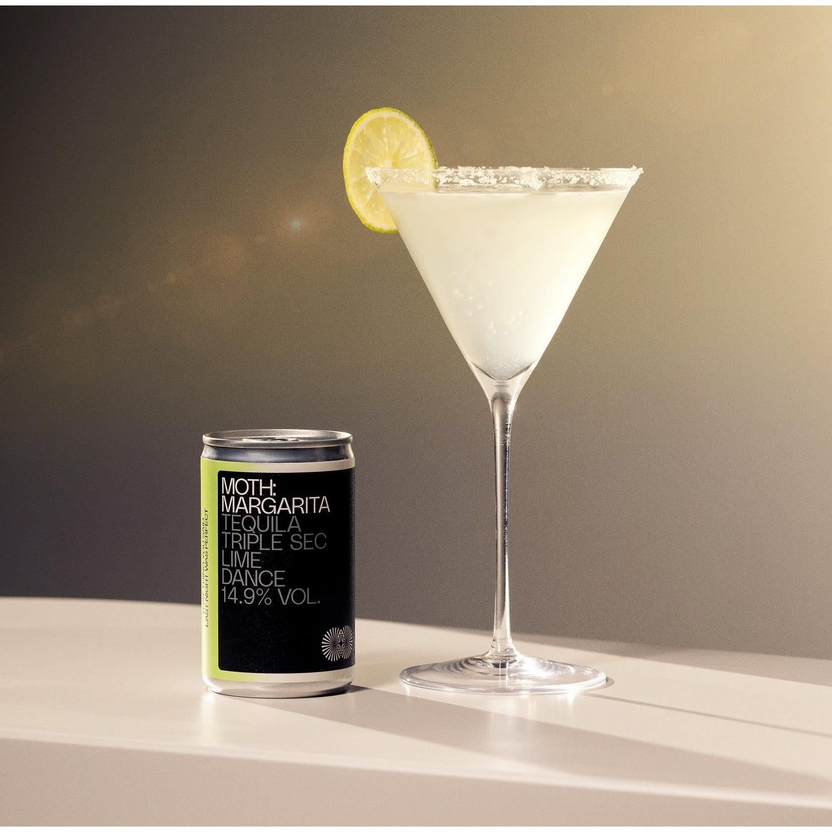 MOTH Margarita cocktail in a martini glass with a lime slice and a matching 125ml can.