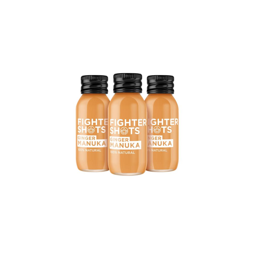 Three orange Fighter Shots Ginger & Manuka bottles with black caps, 60ml, 100% natural.