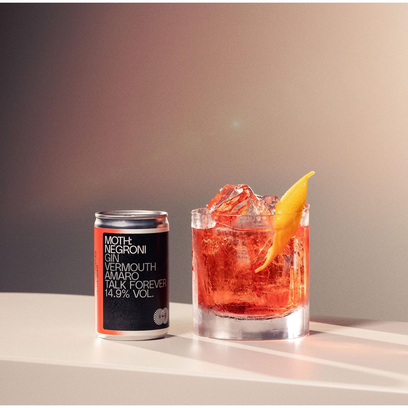 MOTH Negroni cocktail in a silver can and a glass with ice, garnished with an orange peel.