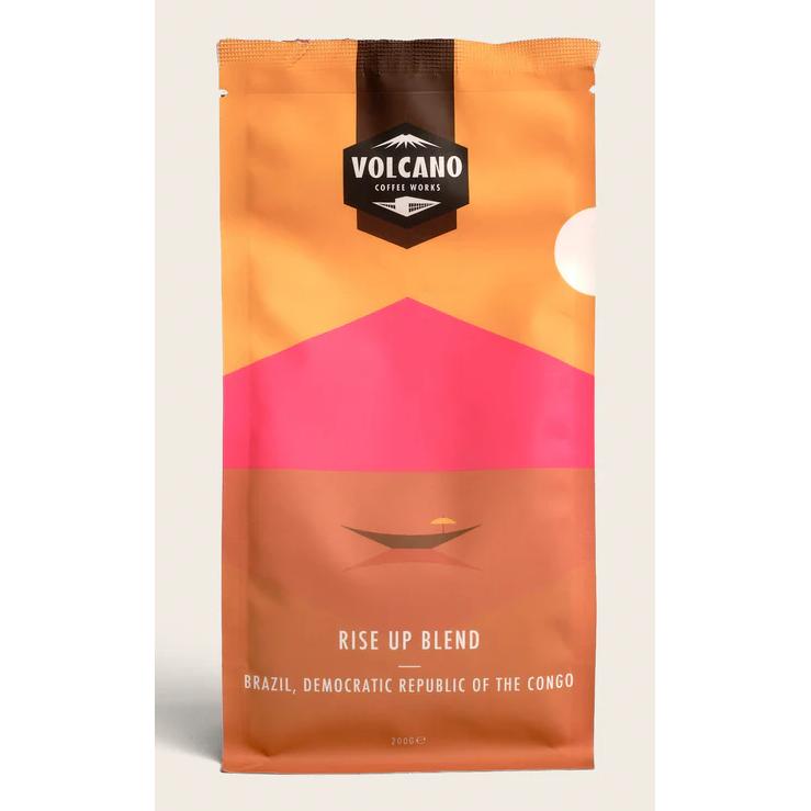 Volcano Coffee Works Rise Up Blend coffee bag with orange, pink, and brown design.
