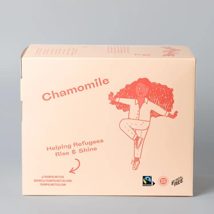 Light peach cardboard box of Trampoline Chamomile tea with a red illustration of a dancing person and "Helping Refugees Rise & Shine.