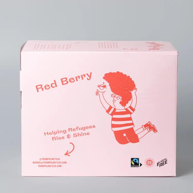 Pink box of Trampoline-Red Berry tea, featuring a red cartoon character holding a teacup, "Helping Refugees Rise & Shine" text.