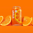 Poppi Orange soda can with water droplets, surrounded by fresh orange halves and whole oranges.