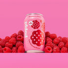 Pink Poppi Raspberry Rose soda can with water droplets, surrounded by fresh raspberries on a pink background.