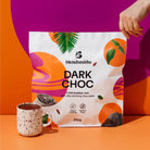 Blendsmiths Dark Choc 2kg bag with tropical design, next to a speckled mug of drinking chocolate.