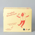 Trampoline English Breakfast tea box, light yellow with red text and a joyful cartoon figure. Organic, Fairtrade, Plastic-Free.