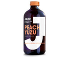 Dark amber glass bottle of Jarr Peach Yuzu Sparkling Kombucha with orange cap and white label.