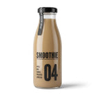 Glass bottle of light brown smoothie with black cap and "SHAKE BEFORE DRINKING" label.