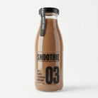 Berry Boost Smoothie in a clear glass bottle with a black cap and label, featuring strawberry, raspberry, and banana.