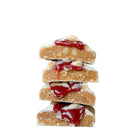 Stack of four YuBi Raspberry Ripple Protein Bar pieces, showing white chocolate coating, pink protein base, and gooey red raspberry caramel.