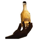 Hand holding a clear, textured glass Soba Circus sparkling nootropic drink bottle with a black cap.