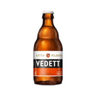 Amber glass bottle of Vedett Extra Pilsner beer with a white and orange label, 330ml.