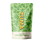 Zuma Classic Ceremonial Matcha Tea 100g in a green pouch with leaf design and yellow "ZUMA" logo.