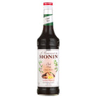 Monin Chai Syrup 1L bottle with dark liquid, red cap, and spiced tea label.