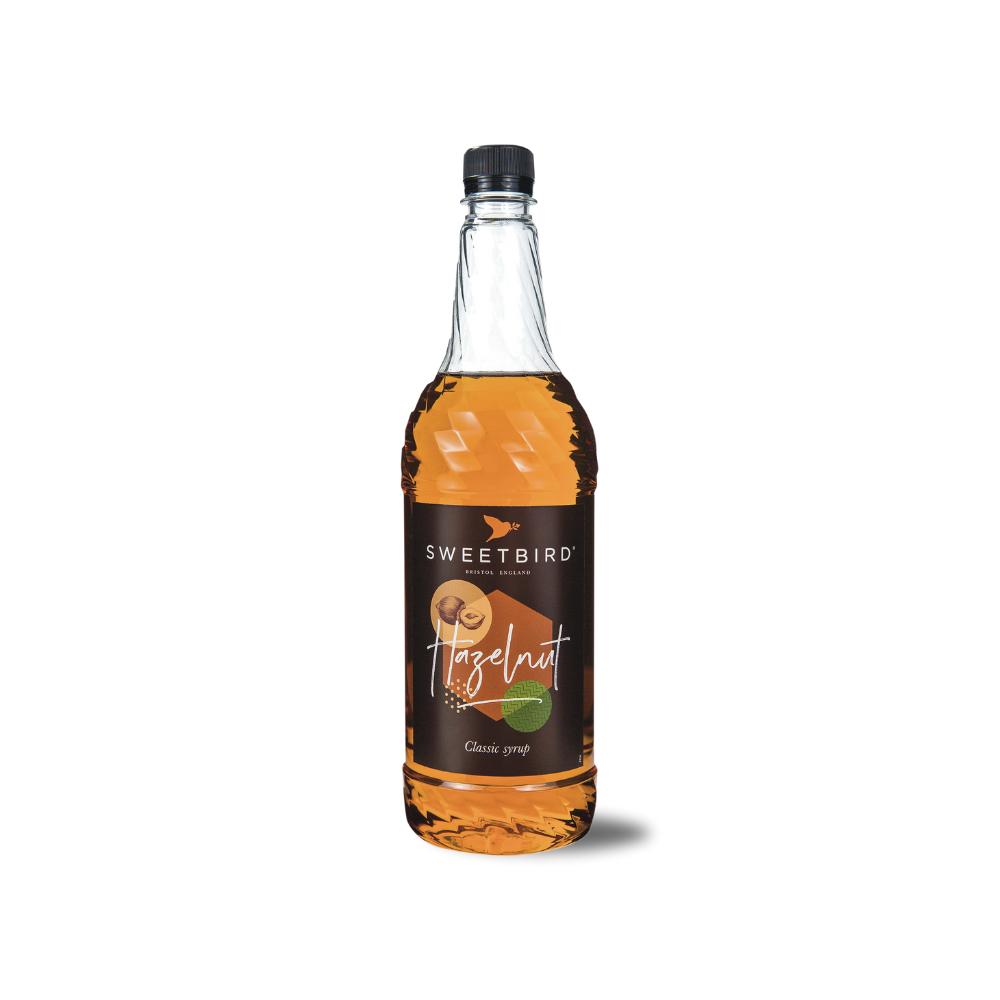 Sweetbird Hazelnut Syrup 1L in a clear glass bottle with a black cap and brown label.